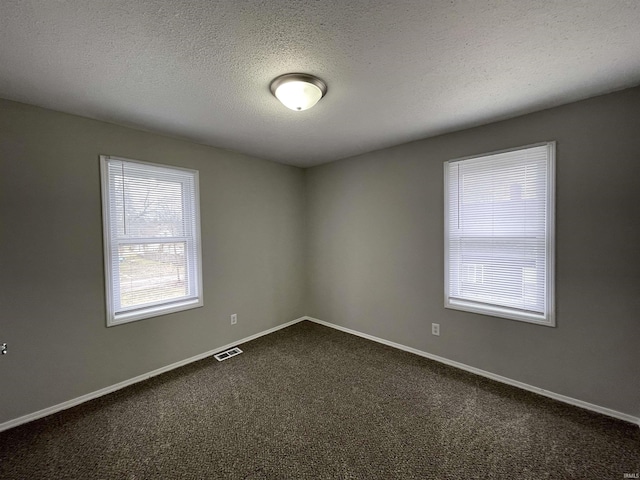 carpeted spare room featuring a textured ceiling