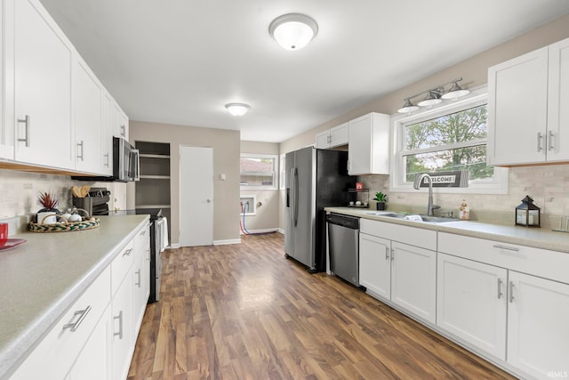 kitchen with plenty of natural light, dark hardwood / wood-style floors, white cabinetry, and stainless steel appliances