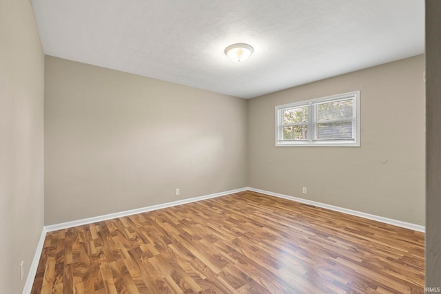 unfurnished room with wood-type flooring