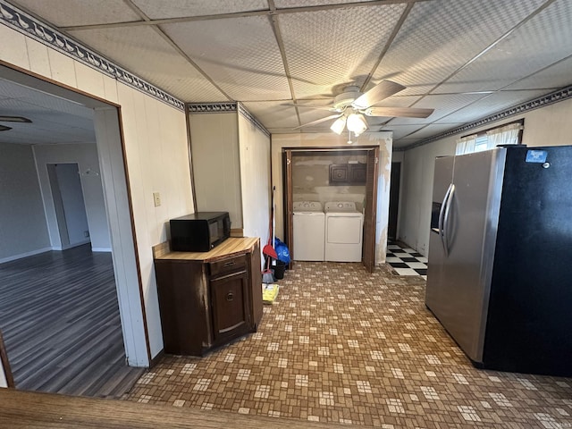 kitchen with stainless steel fridge with ice dispenser, ceiling fan, and washing machine and clothes dryer