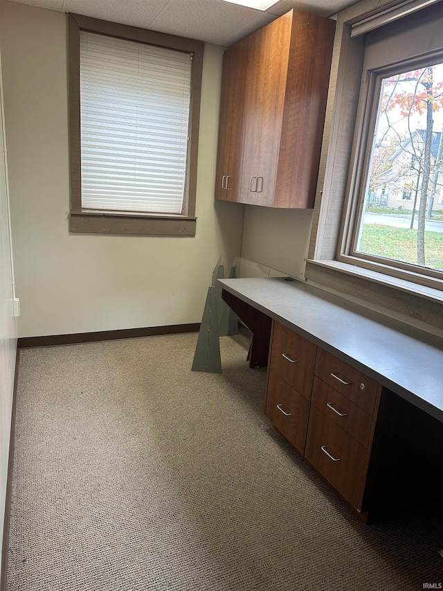 unfurnished office featuring dark colored carpet and built in desk