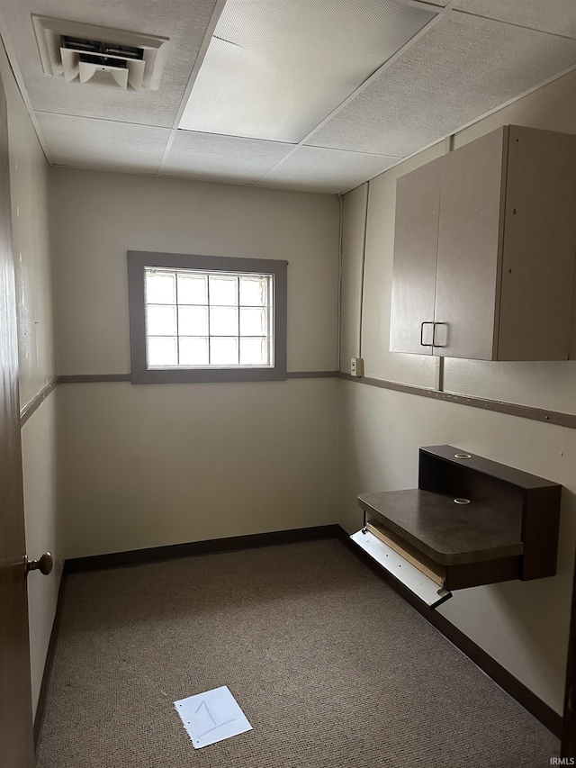 interior space with carpet flooring and a drop ceiling