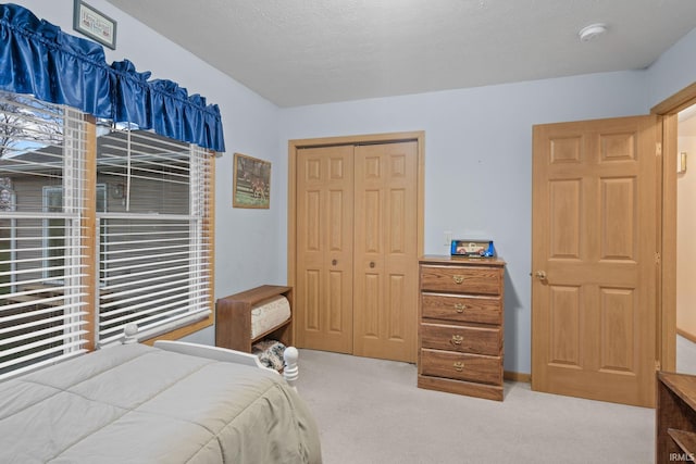 carpeted bedroom with a textured ceiling and a closet