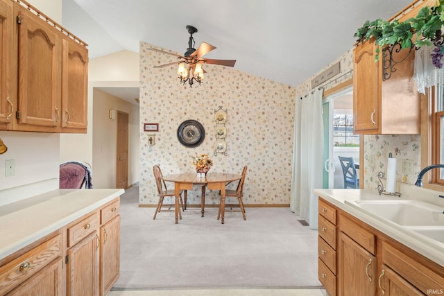 kitchen with ceiling fan, sink, lofted ceiling, and light carpet