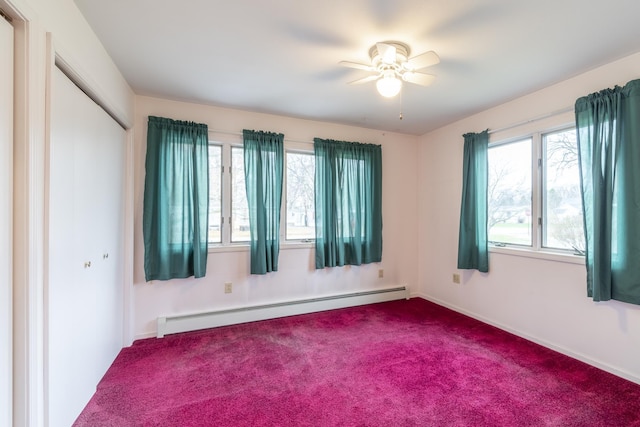 carpeted empty room featuring baseboard heating and ceiling fan