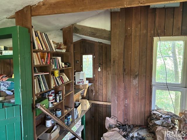 misc room featuring wood walls and vaulted ceiling