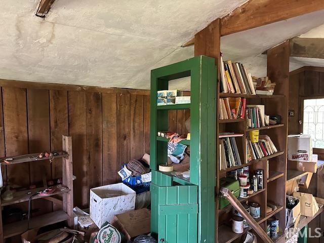 misc room featuring wooden walls and vaulted ceiling