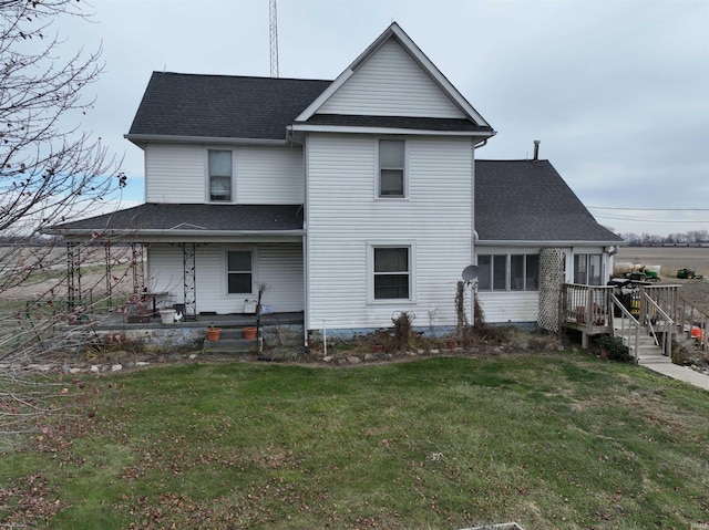 back of house featuring a sunroom, covered porch, and a lawn