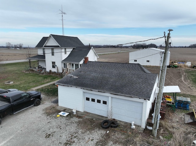 view of property exterior featuring a rural view and a garage