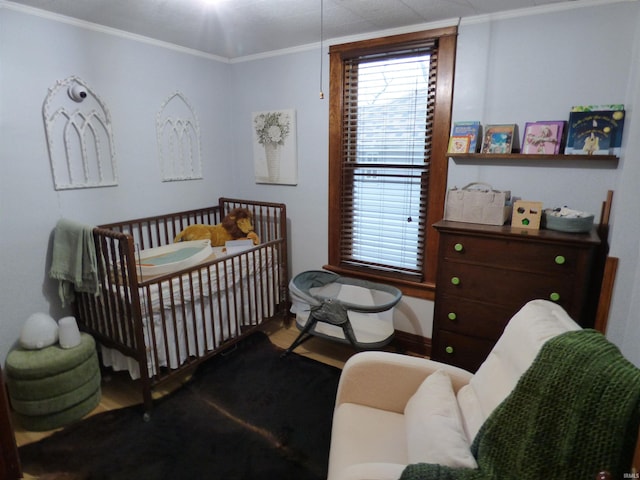 bedroom with crown molding and a nursery area