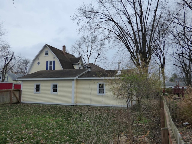 view of side of home with a yard