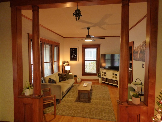 living room with hardwood / wood-style flooring, ceiling fan, ornamental molding, and ornate columns