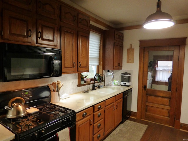 kitchen with decorative backsplash, crown molding, sink, dark wood-type flooring, and black appliances