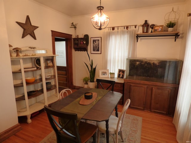 dining space with light wood-type flooring and an inviting chandelier