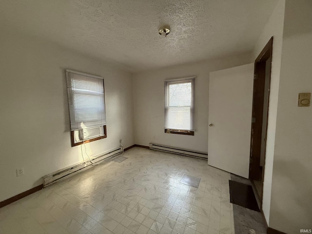 empty room featuring a textured ceiling and a baseboard heating unit