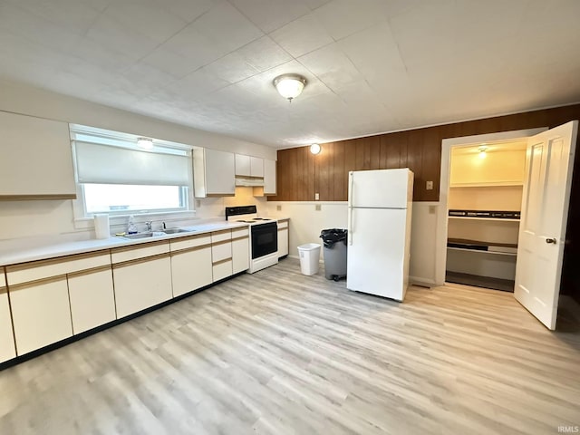 kitchen with white cabinets, white appliances, light hardwood / wood-style flooring, and sink