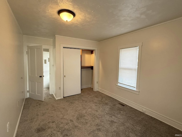 unfurnished bedroom with carpet floors, a textured ceiling, and a closet