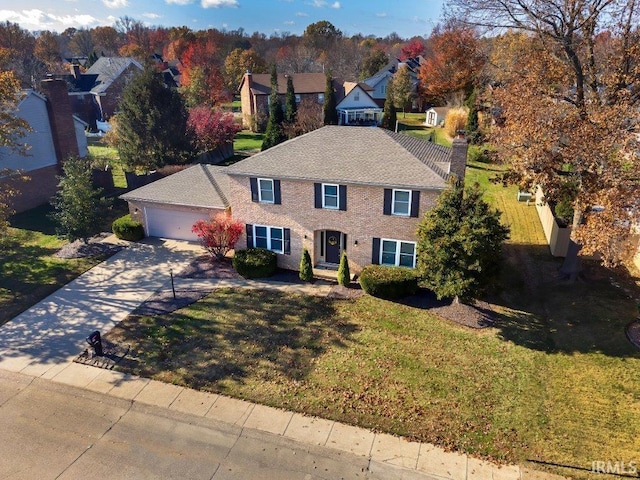 colonial home featuring a garage and a front yard