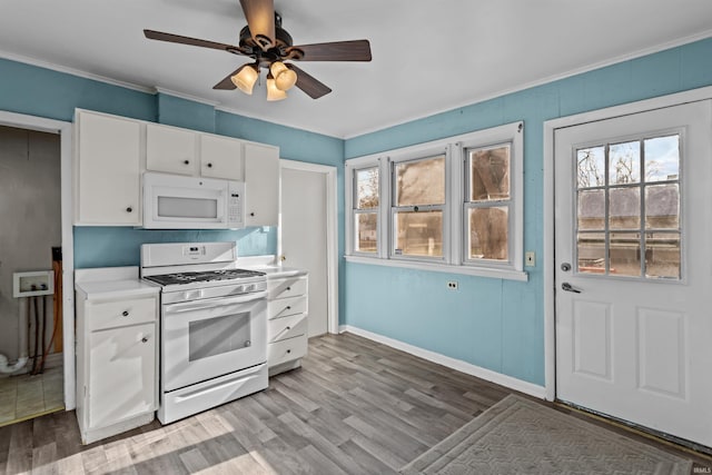 kitchen featuring white appliances, crown molding, ceiling fan, light wood-type flooring, and white cabinetry