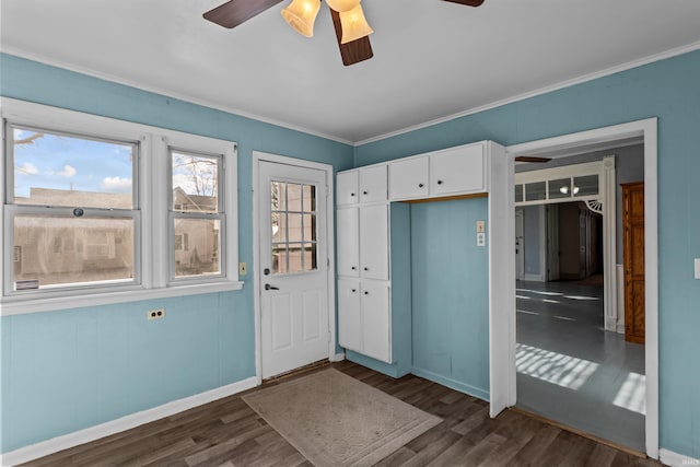 foyer with ornamental molding, ceiling fan, and dark wood-type flooring