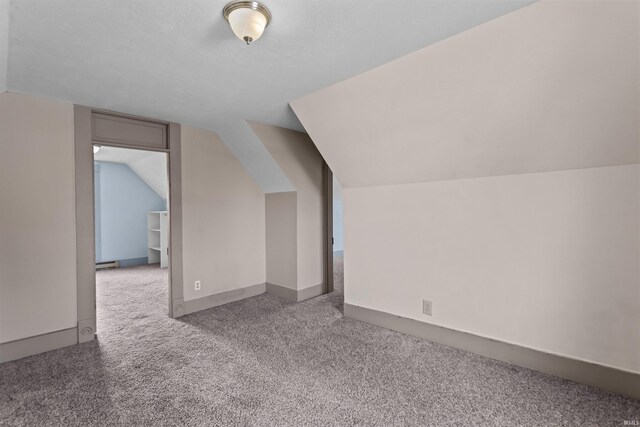 additional living space featuring lofted ceiling and light carpet