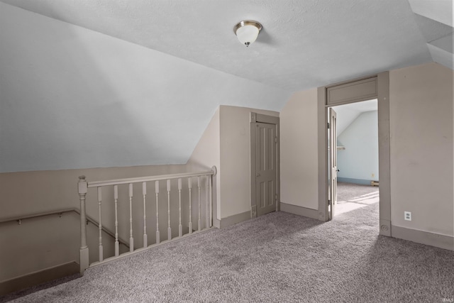 bonus room featuring carpet flooring, a textured ceiling, and lofted ceiling