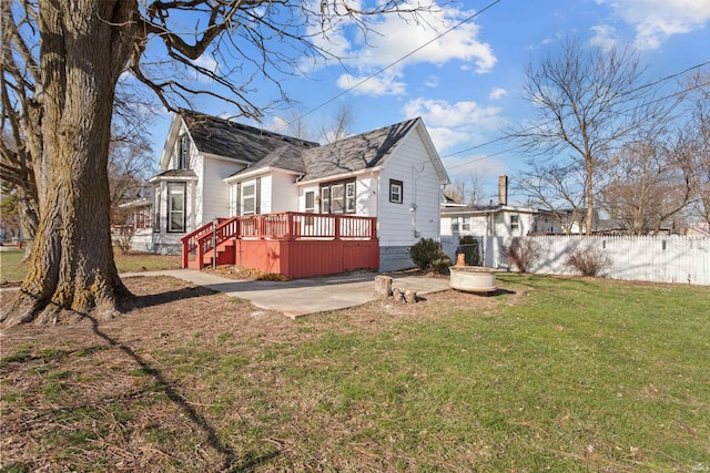 rear view of property with a lawn, a patio area, and a wooden deck