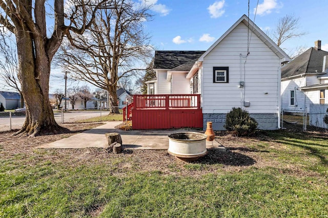 rear view of property with a wooden deck, a yard, and a patio