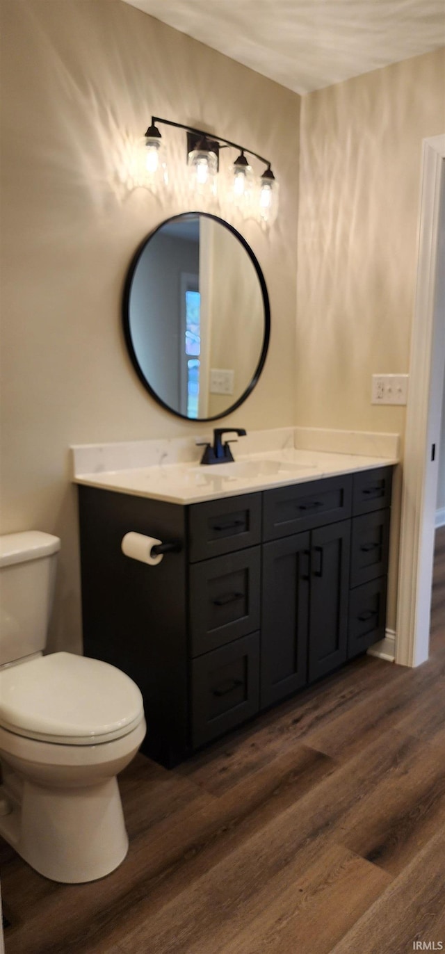 bathroom featuring wood-type flooring, vanity, and toilet