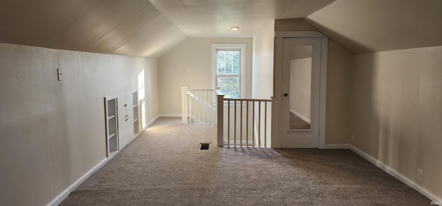 additional living space with carpet flooring and vaulted ceiling