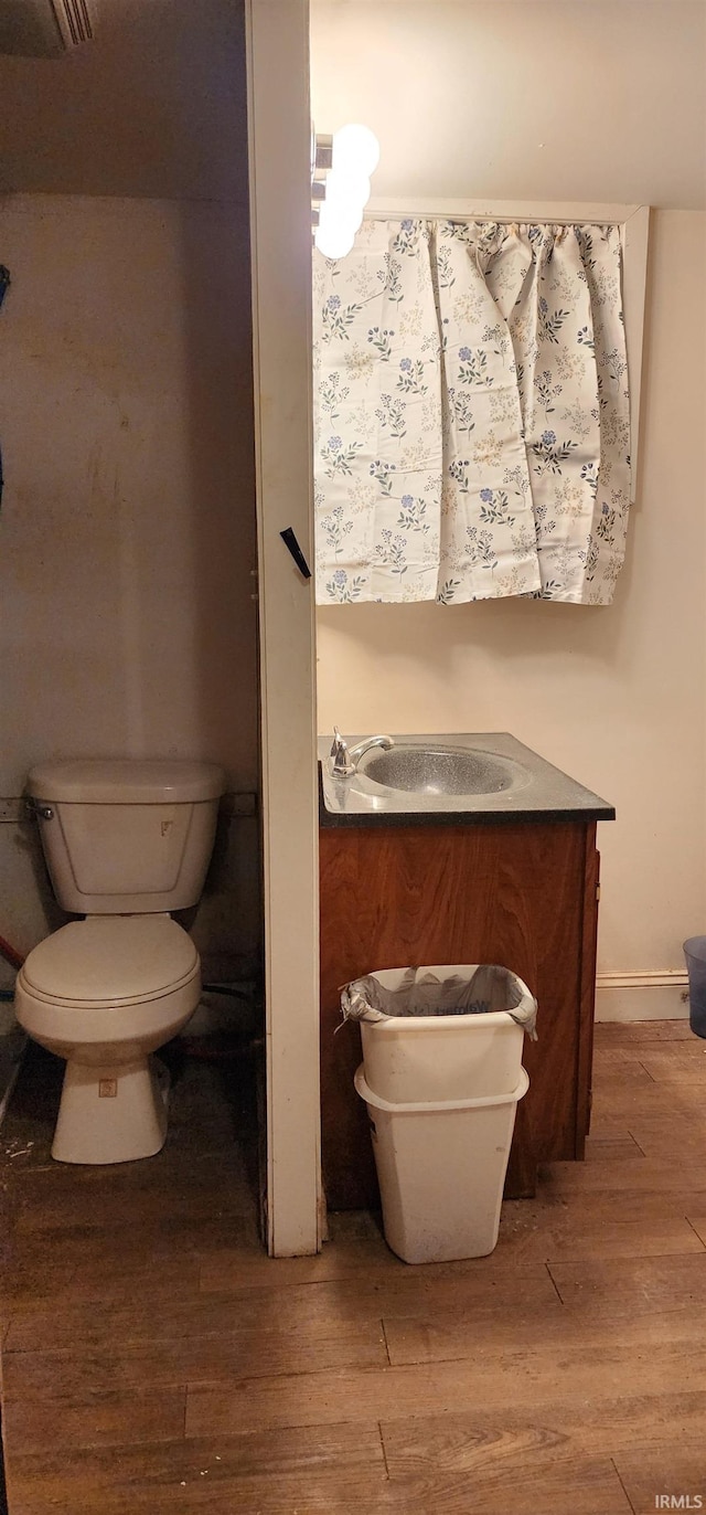 bathroom with vanity, wood-type flooring, and toilet