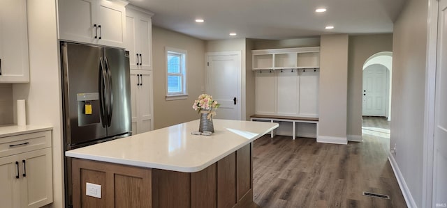 kitchen featuring white cabinetry, stainless steel fridge with ice dispenser, hardwood / wood-style floors, and a center island