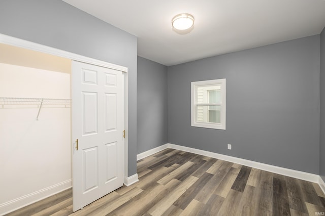 unfurnished bedroom featuring a closet and dark hardwood / wood-style floors