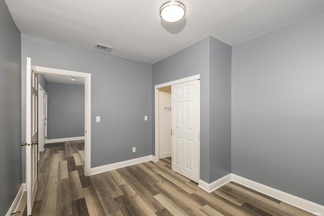 unfurnished bedroom with a closet and dark wood-type flooring