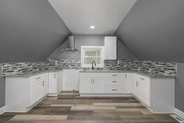 kitchen with decorative backsplash, dark wood-type flooring, sink, white cabinets, and lofted ceiling