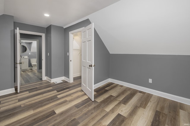 bonus room featuring dark wood-type flooring and lofted ceiling