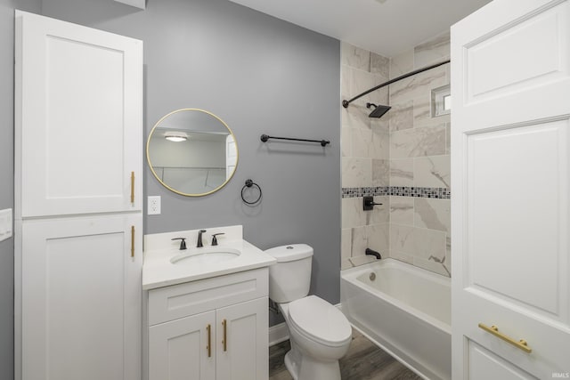 full bathroom featuring vanity, wood-type flooring, tiled shower / bath combo, and toilet