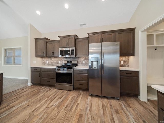 kitchen with tasteful backsplash, light hardwood / wood-style flooring, and appliances with stainless steel finishes