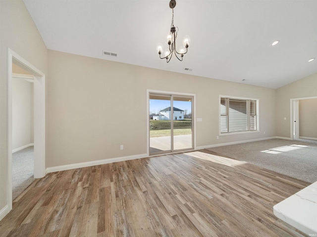 interior space featuring lofted ceiling, light hardwood / wood-style flooring, and a chandelier