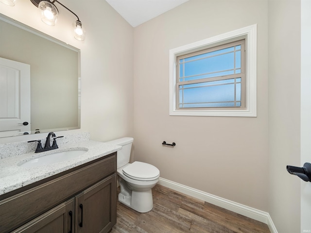 bathroom featuring vanity, wood-type flooring, and toilet