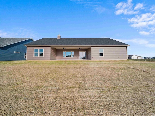 rear view of property with a lawn and ceiling fan