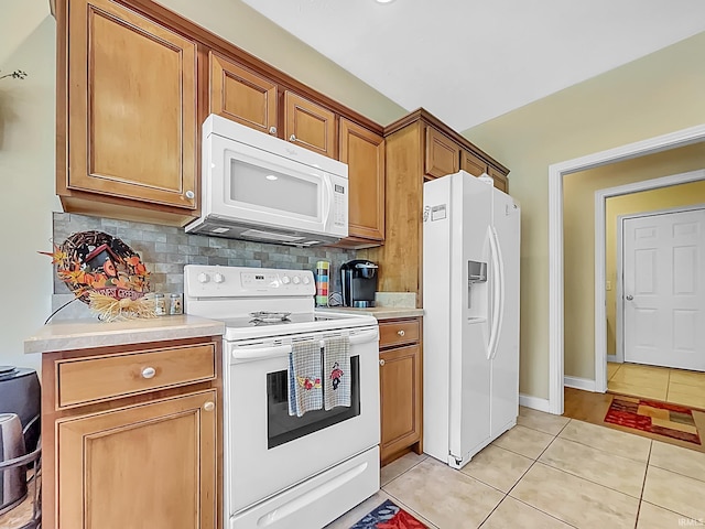 kitchen featuring light tile patterned floors, white appliances, and tasteful backsplash