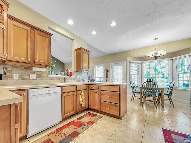 kitchen with a notable chandelier, dishwasher, a wealth of natural light, and vaulted ceiling