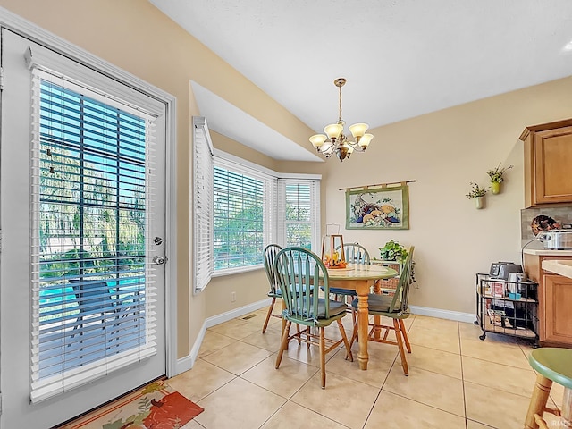 dining area featuring light tile patterned flooring and a notable chandelier