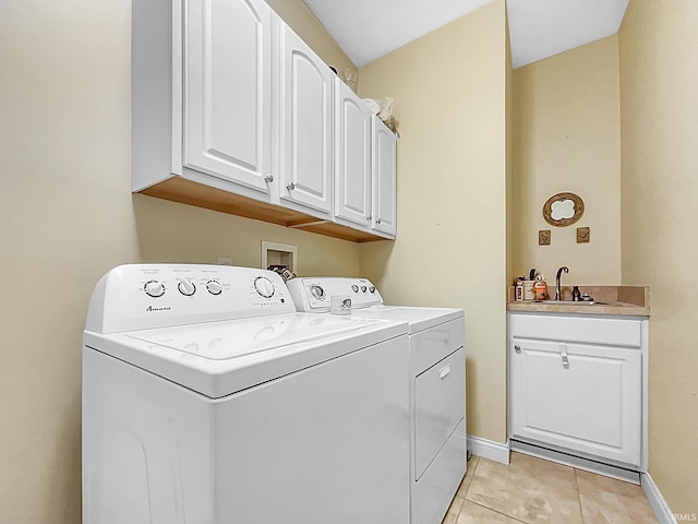 laundry room with cabinets, light tile patterned floors, sink, and washing machine and clothes dryer