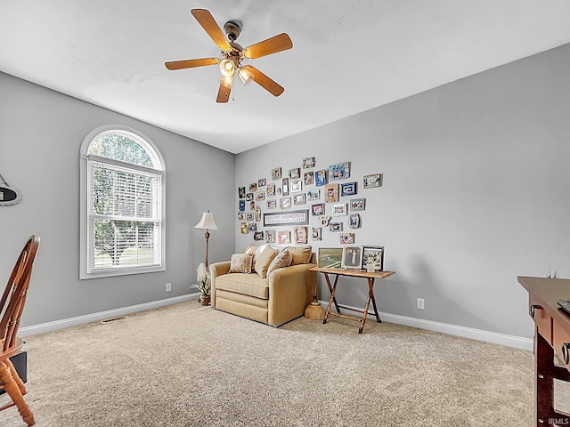 living area with ceiling fan and light colored carpet