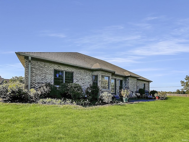 rear view of house with a yard and a patio area