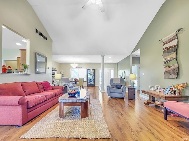 living room featuring high vaulted ceiling, light hardwood / wood-style floors, ornate columns, and ceiling fan