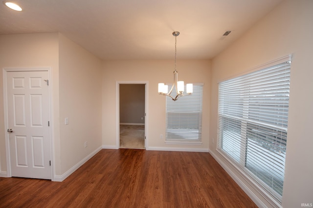 unfurnished dining area with dark hardwood / wood-style floors and a notable chandelier