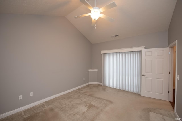 carpeted empty room featuring ceiling fan and vaulted ceiling